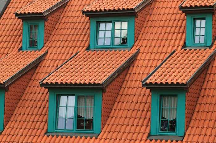 Orange clay barrel tile roof with dormer windows